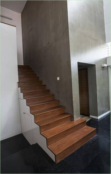 A wooden inter-level staircase with a pantry
