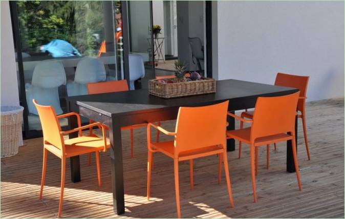 Black dining table with bright orange chairs