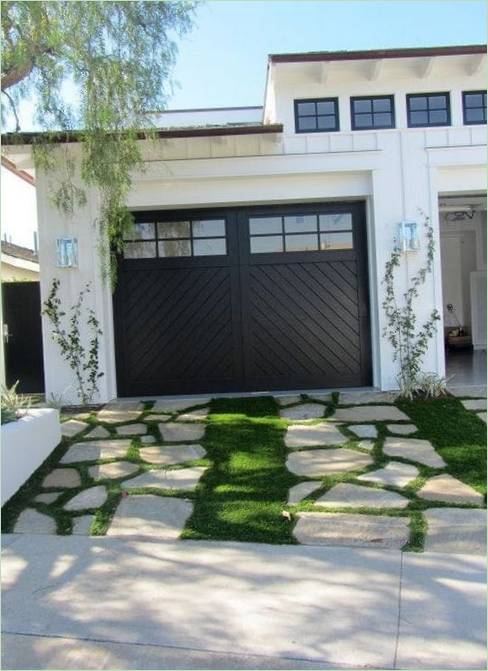A path of green grass and stones in front of the garage