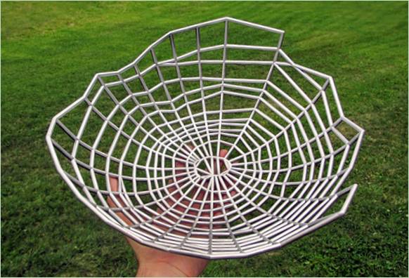 A designer metal basket in the shape of a woven web