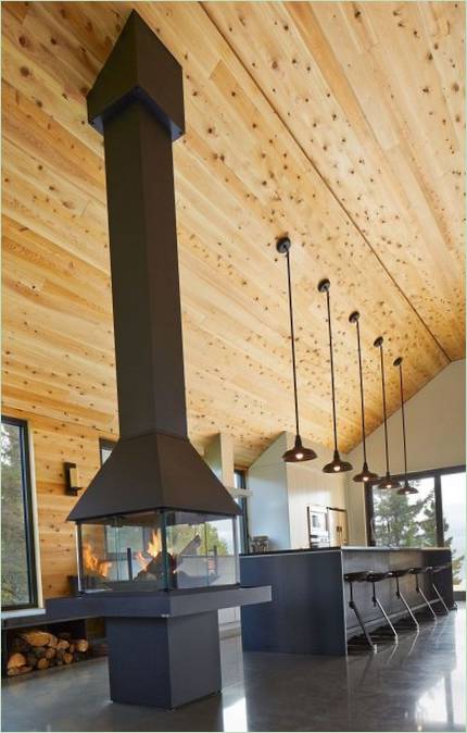 The design of a wooden house in Quebec: a glass fireplace in the kitchen interior